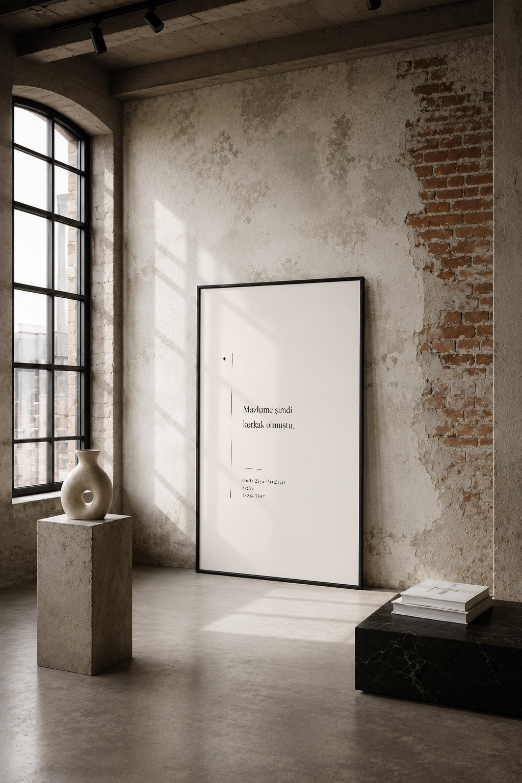Minimalist tasarımı ve sade metin detayıyla endüstriyel mekanda duran siyah çerçeveli poster.